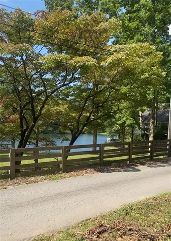 a small yard with wooden fence and trees