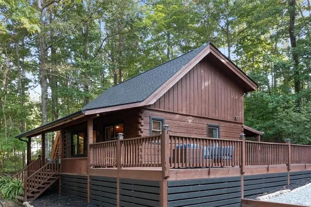 a view of barn house with a small yard and wooden fence