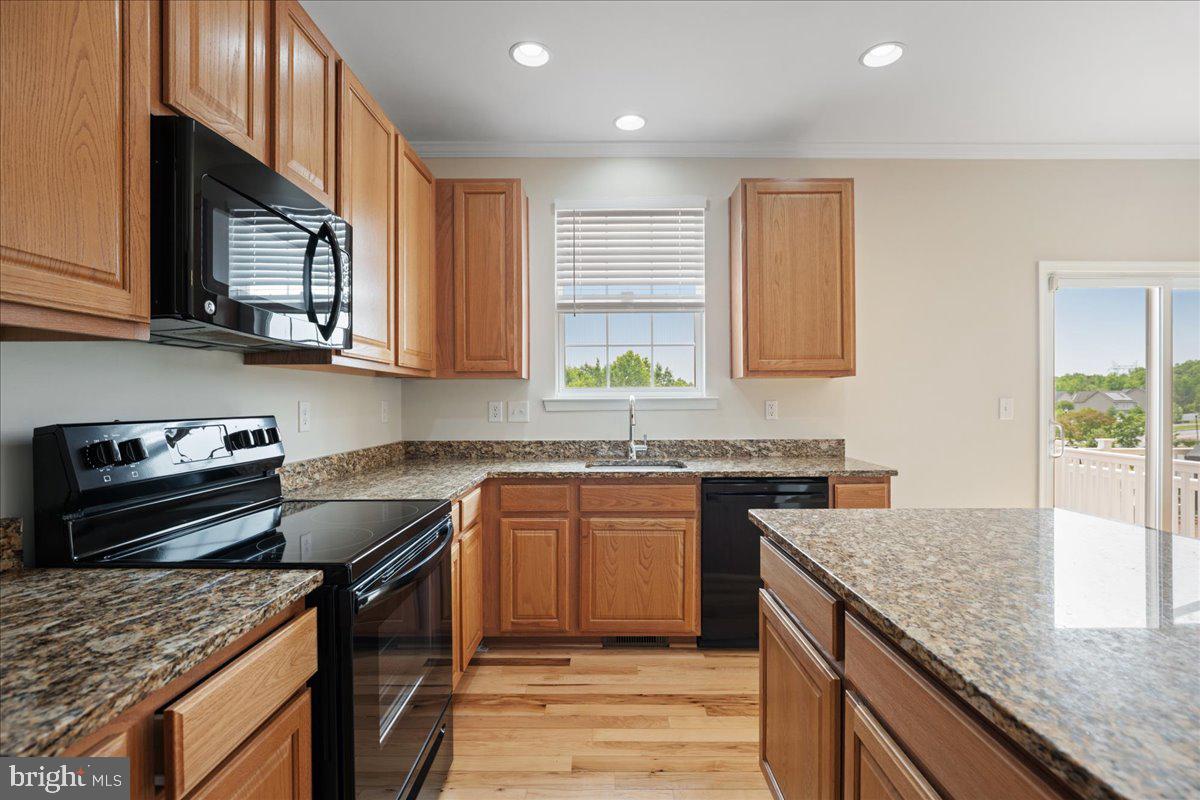 126 Backstretch Way Prince Frederick, MD 20678 - Photo 11 of 49 a kitchen with stainless steel appliances granite countertop a stove a sink and a microwave
