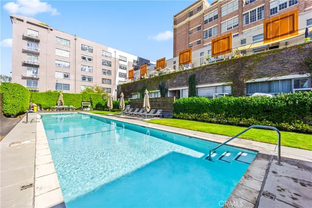 a view of building with swimming pool and lawn chairs