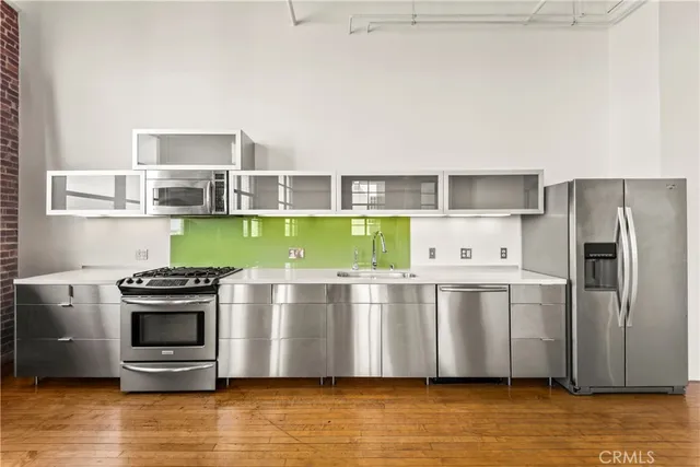 a kitchen with stainless steel appliances a stove a refrigerator and a sink