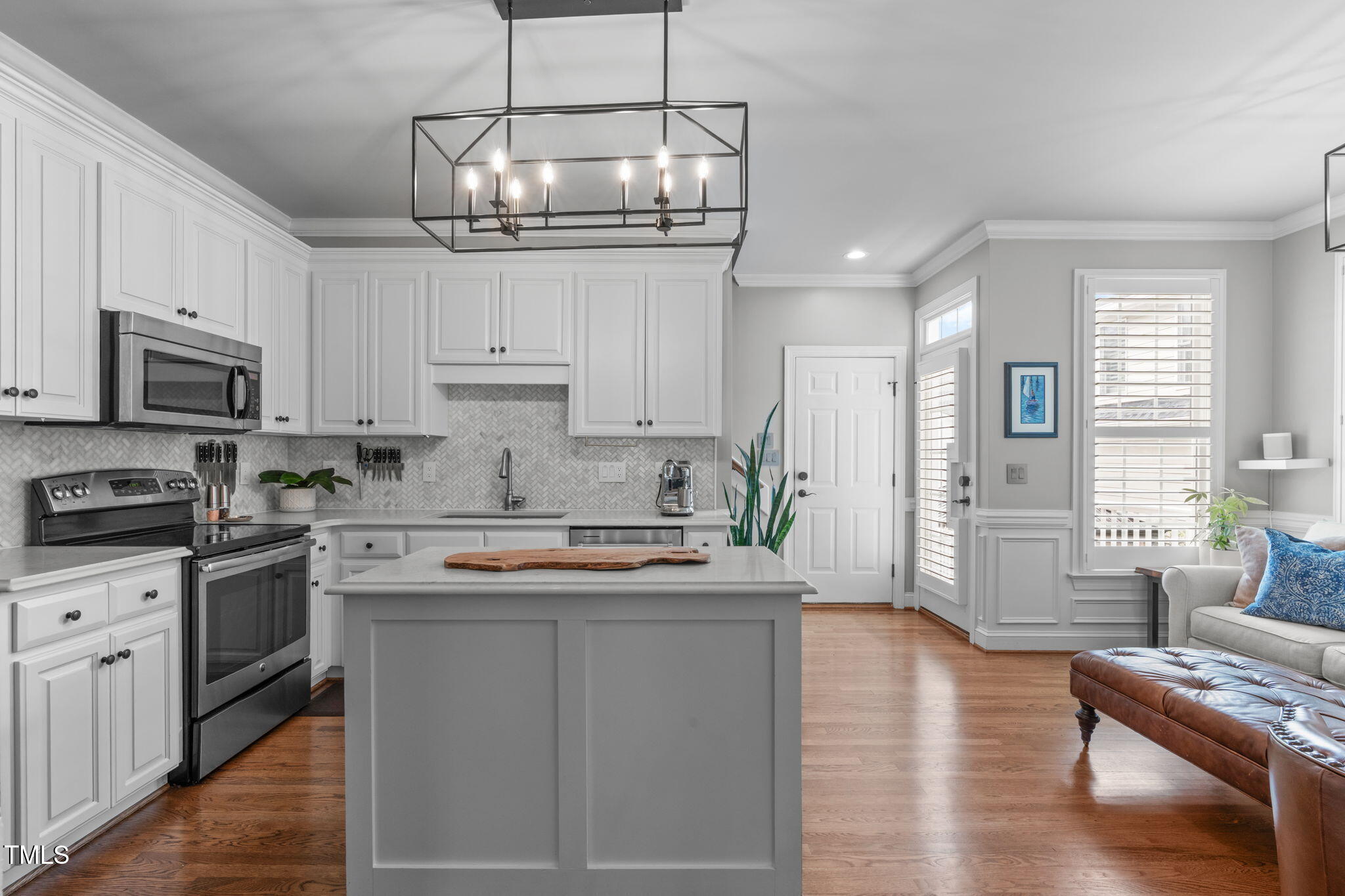 321 Commons Walk Circle Cary, NC 27519 - Photo 15 of 54 a kitchen with stainless steel appliances granite countertop a stove top oven a refrigerator a sink dishwasher a dining table and chairs with wooden floor