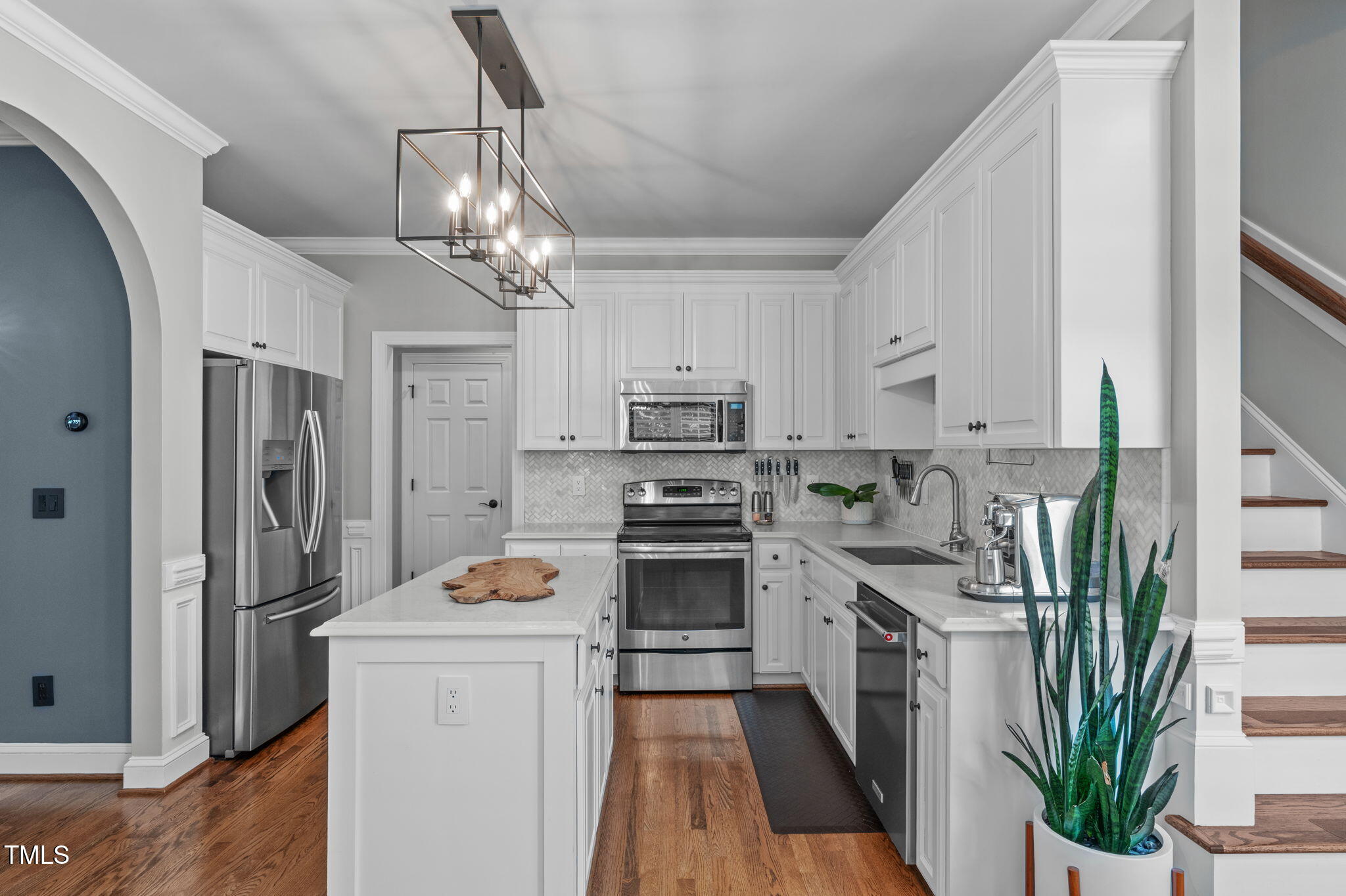 321 Commons Walk Circle Cary, NC 27519 - Photo 18 of 54 a kitchen with stainless steel appliances granite countertop a refrigerator a stove a sink dishwasher and white cabinets with wooden floor