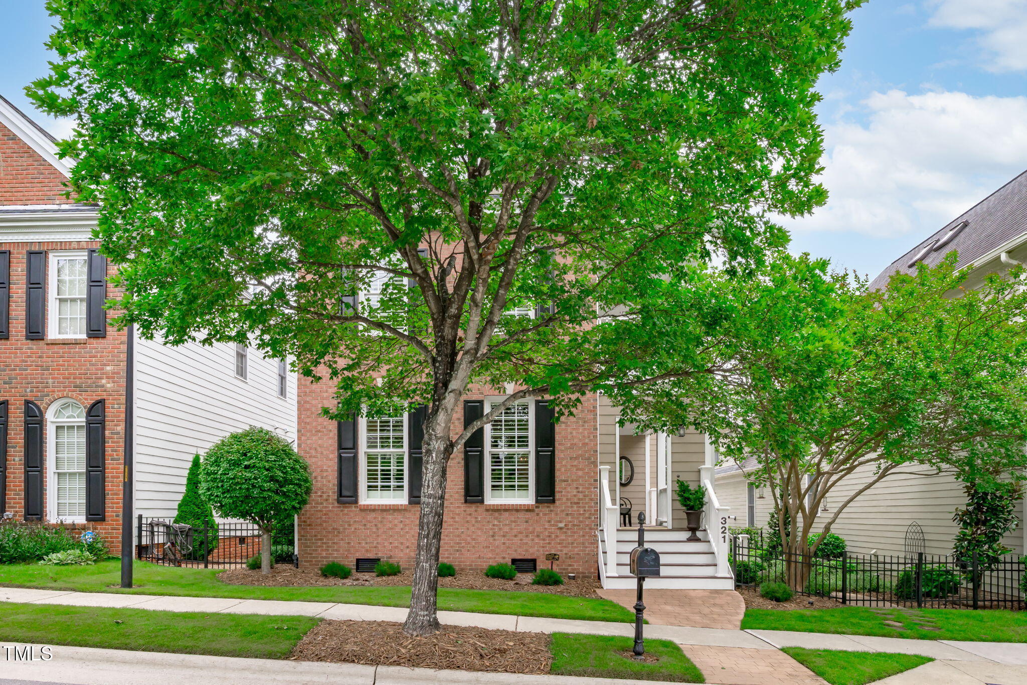 321 Commons Walk Circle Cary, NC 27519 - Photo 2 of 54 a front view of a house with a yard and an trees