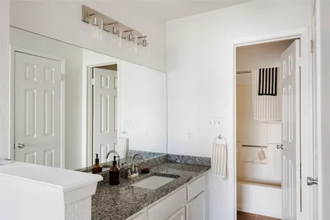 a bathroom with a granite countertop sink and a mirror