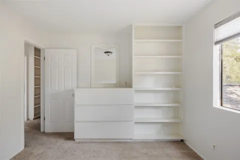 a view of walk in closet with empty racks