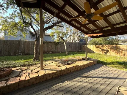 a view of a backyard with table and chairs and wooden fence