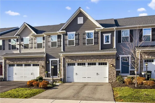 a front view of a house with a yard and garage