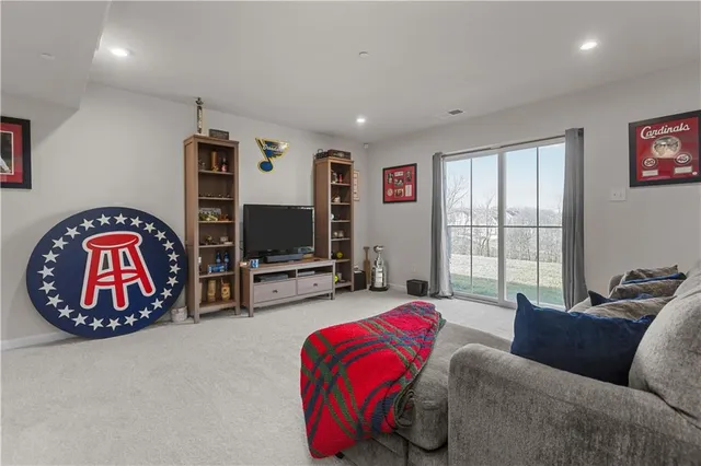 a living room with furniture a flat screen tv and a large window