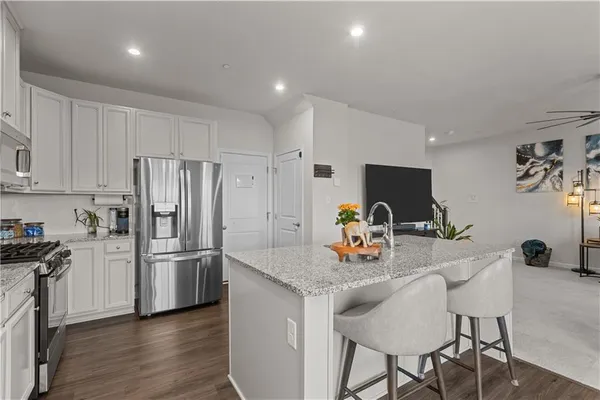 a kitchen with stainless steel appliances granite countertop a refrigerator and a stove top oven
