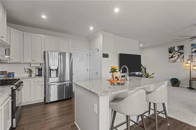 a kitchen with stainless steel appliances granite countertop a refrigerator and a stove top oven
