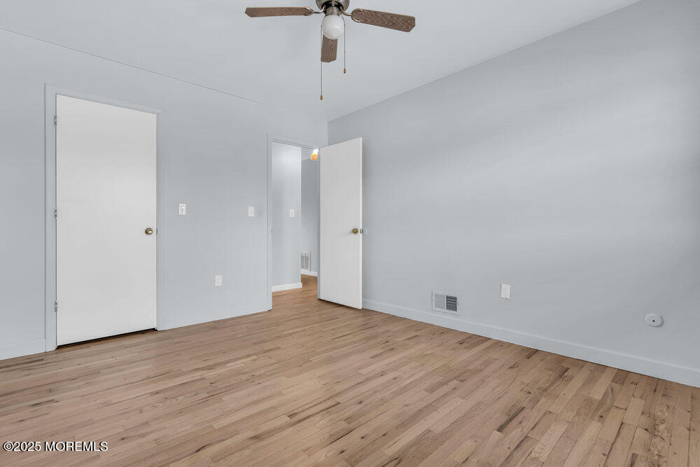 3403 Bridge Avenue, Unit 13 Point Pleasant, NJ 08742 - Photo 12 of 27 a view of an empty room with a ceiling fan and wooden floor