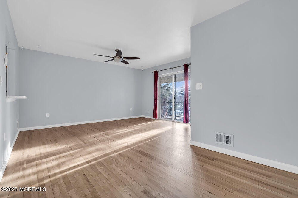 3403 Bridge Avenue, Unit 13 Point Pleasant, NJ 08742 - Photo 3 of 27 a view of a livingroom with wooden floor and a ceiling fan