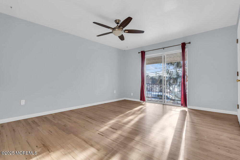 3403 Bridge Avenue, Unit 13 Point Pleasant, NJ 08742 - Photo 5 of 27 a view of a livingroom with a ceiling fan and wooden floor