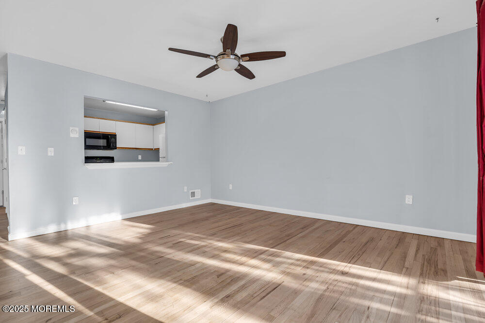 3403 Bridge Avenue, Unit 13 Point Pleasant, NJ 08742 - Photo 7 of 27 a view of a room with wooden floor and a ceiling fan
