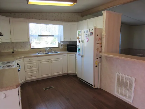 a kitchen with white cabinets and white appliances