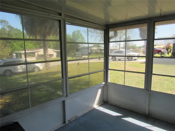 a view of a porch with chairs and backyard