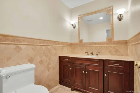 a bathroom with a sink vanity mirror and toilet