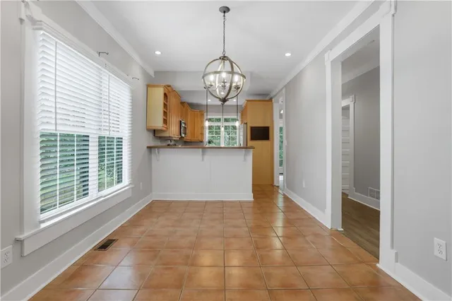 a view of a big room with wooden floor windows and a chandelier