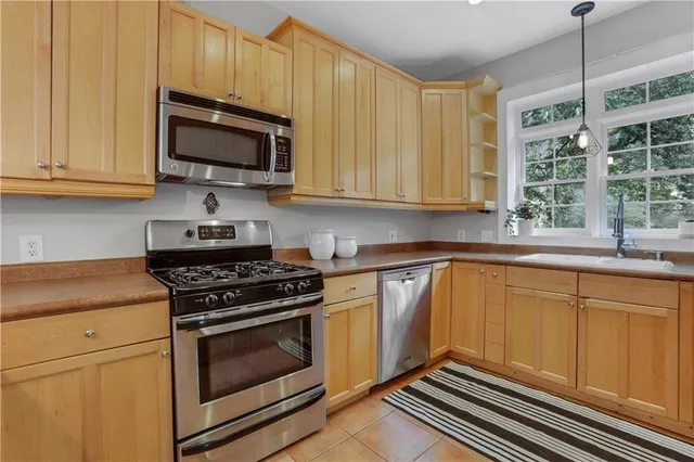 a kitchen with granite countertop a stove a sink and wooden cabinets