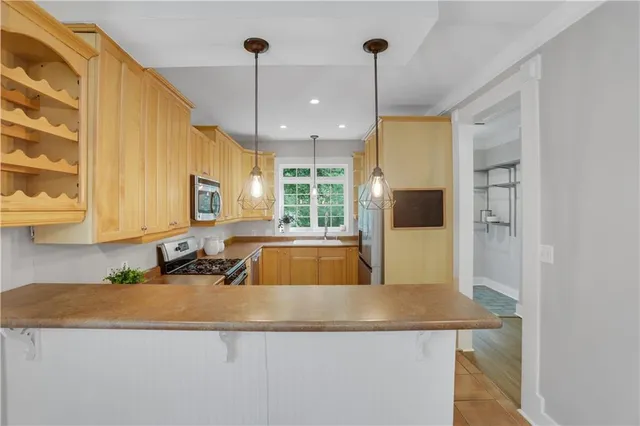 a kitchen with kitchen island granite countertop a sink a counter top space and cabinets