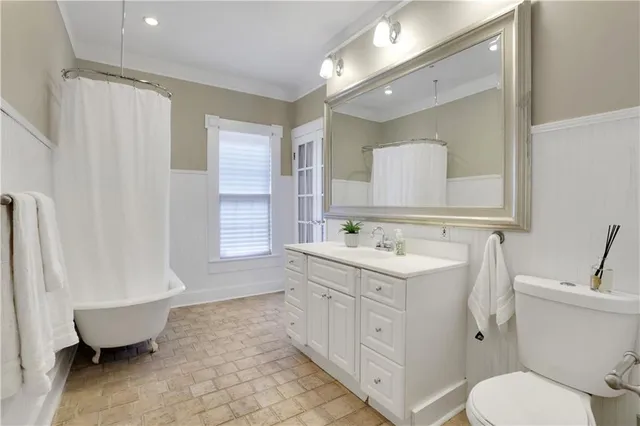 a bathroom with a sink toilet vanity and tub