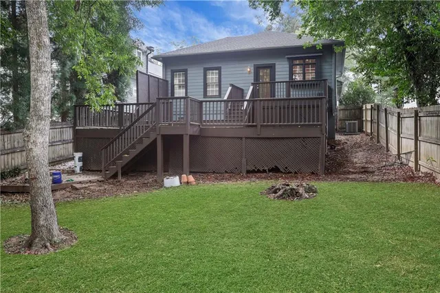 a view of a house with a yard and a wooden deck