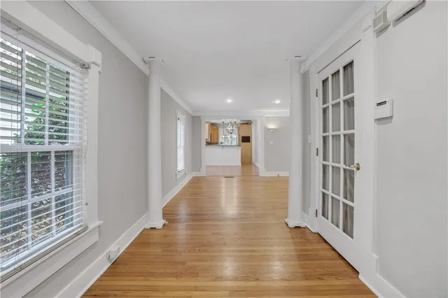 a hallway with wooden floor and windows