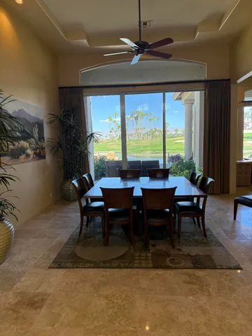 a kitchen with stainless steel appliances granite countertop table chairs sink and cabinets