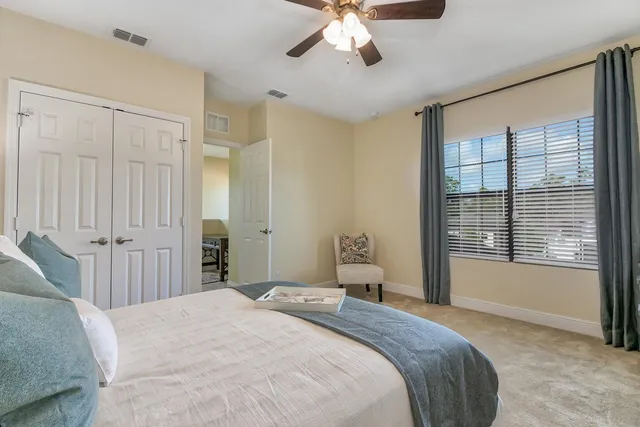 a bedroom with a large bed and a chandelier