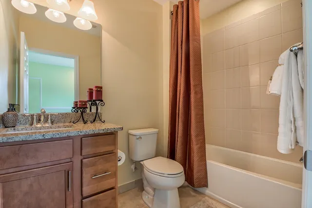a bathroom with a granite countertop toilet a sink and a bathtub