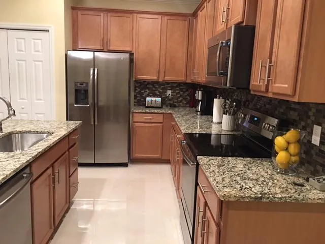 a kitchen with stainless steel appliances granite countertop a sink stove and refrigerator