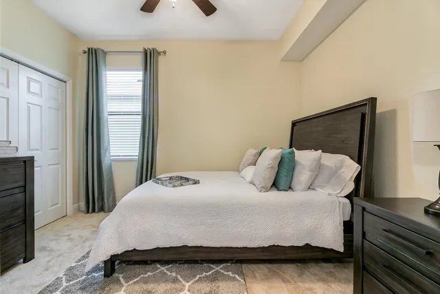 a bedroom with a bed and a flat tv screen on the dresser