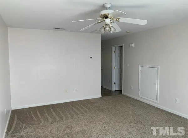 an empty room with a chandelier fan