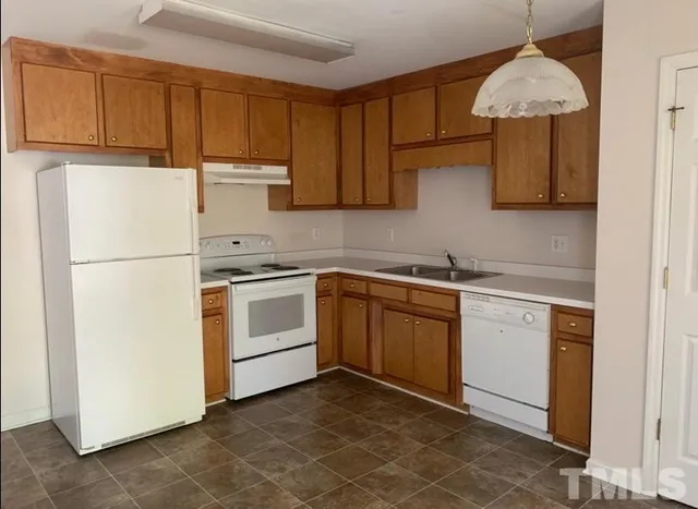a kitchen with a refrigerator sink and cabinets