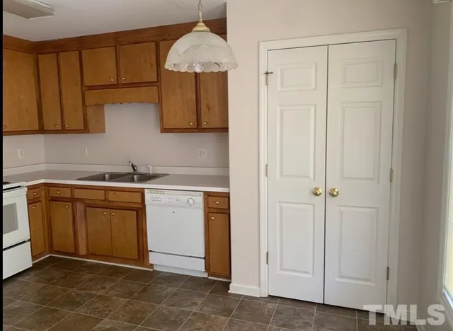 a kitchen with stainless steel appliances granite countertop a sink a stove and a refrigerator