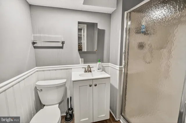 a bathroom with a toilet a sink and mirror