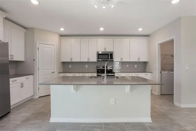a large kitchen with white cabinets