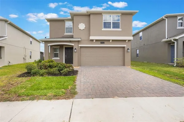 a front view of a house with a yard and garage