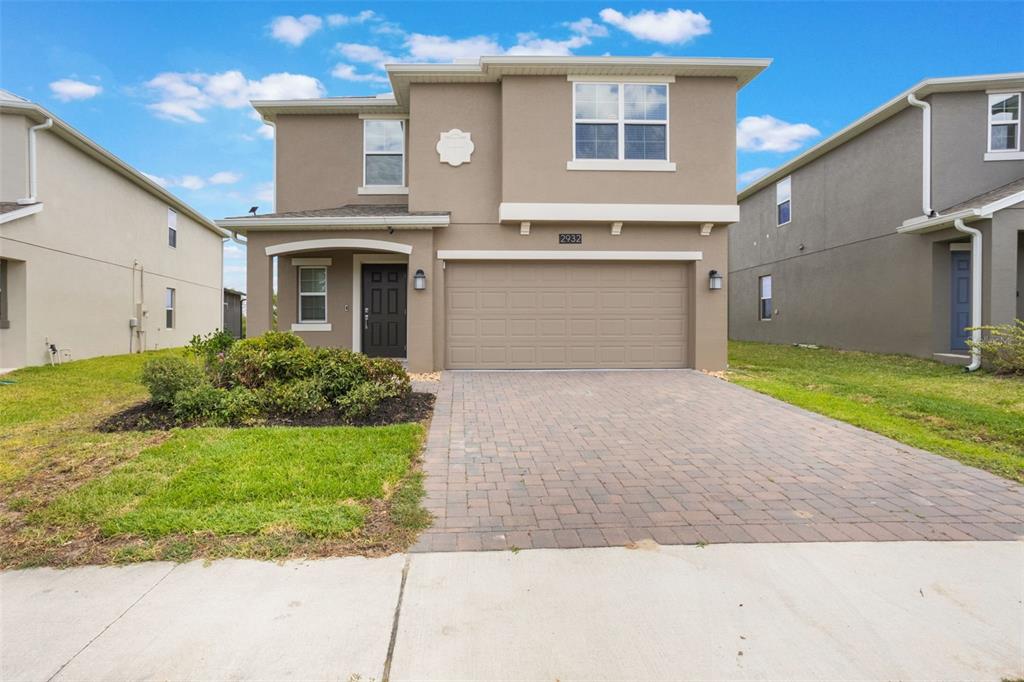 2932 Muller Oak Loop Ocoee, FL 34761 - Photo 2 of 32 a front view of a house with a yard and garage