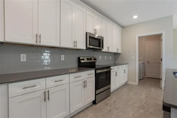 a kitchen with granite countertop white cabinets stainless steel appliances and sink