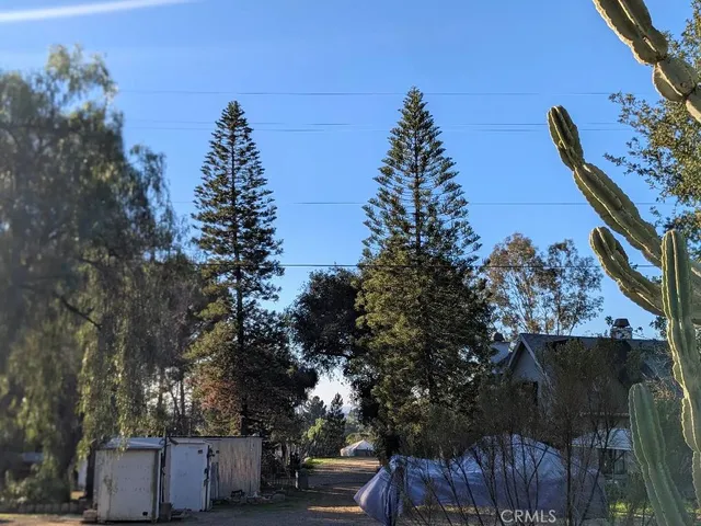 a backyard of a house with table and chairs under an umbrella
