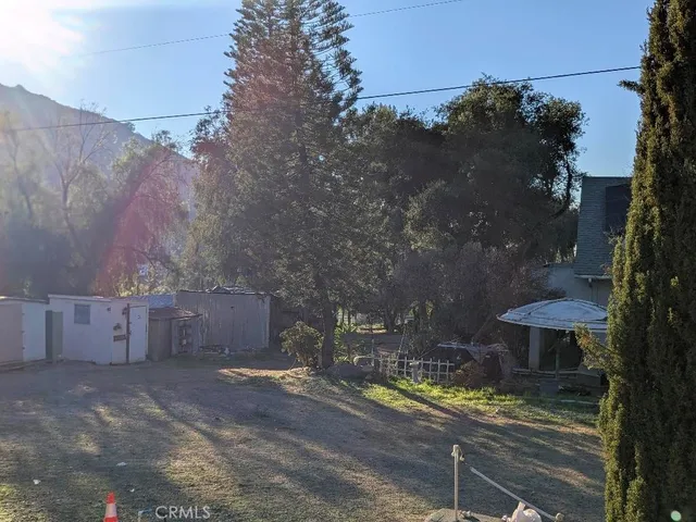 a view of swimming pool with outdoor seating and trees in the background