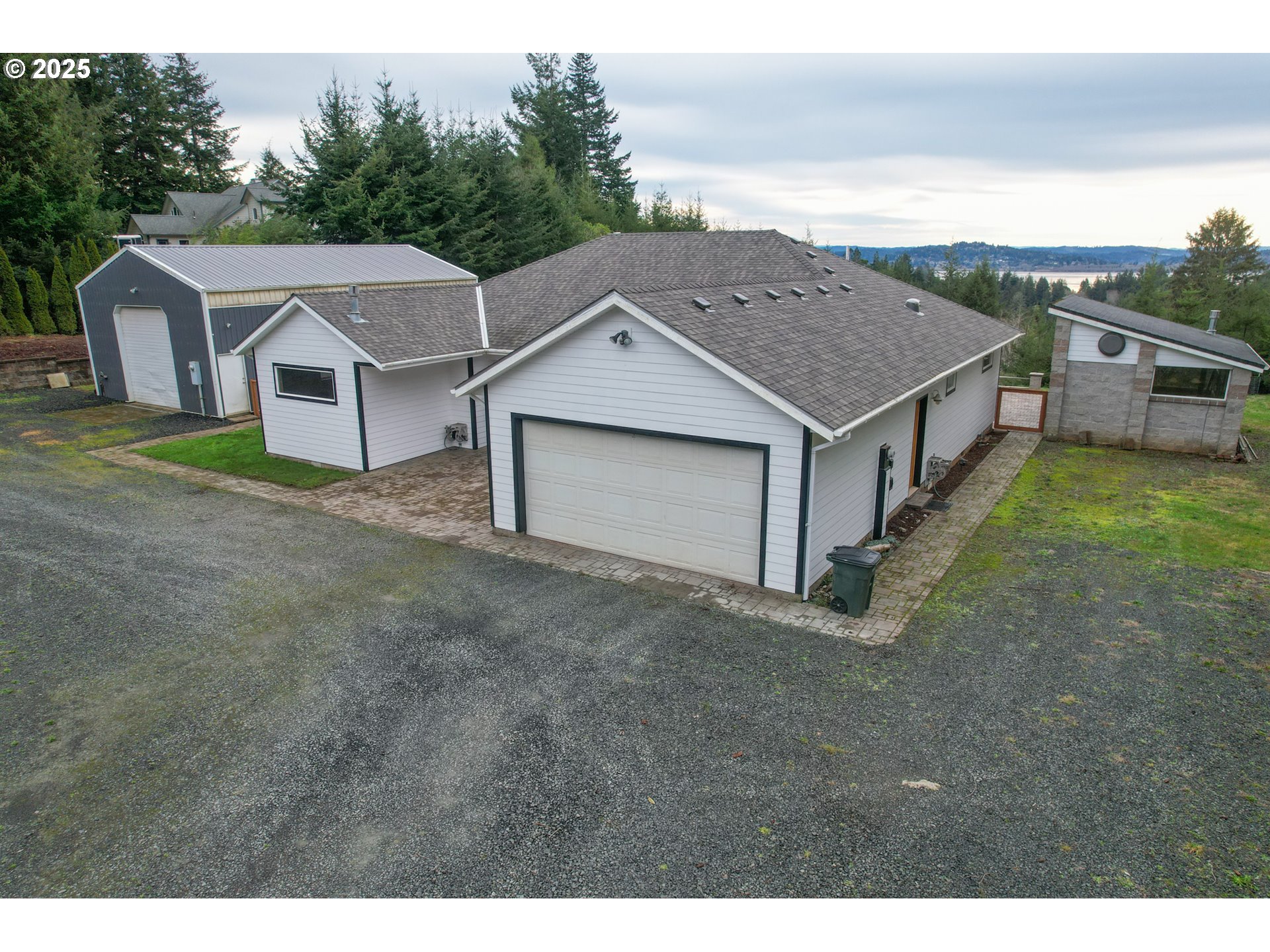 a aerial view of a house in front of a big yard with large tree
