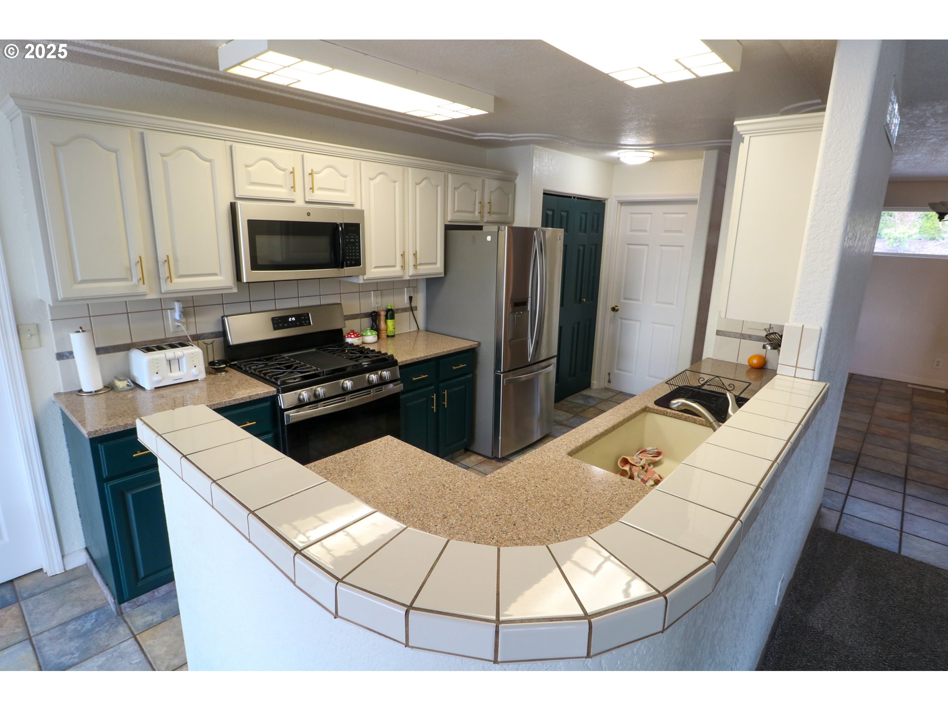 94088 Kirkendall Lane North Bend, OR 97459 - Photo 15 of 46 a kitchen with stainless steel appliances kitchen island granite countertop a refrigerator and a stove top oven