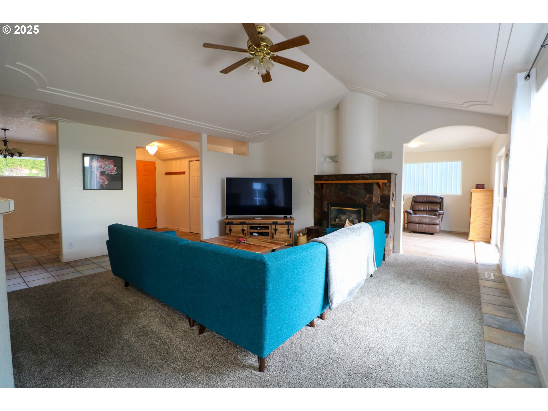 94088 Kirkendall Lane North Bend, OR 97459 - Photo 17 of 46 a living room with furniture a fireplace and a flat screen tv