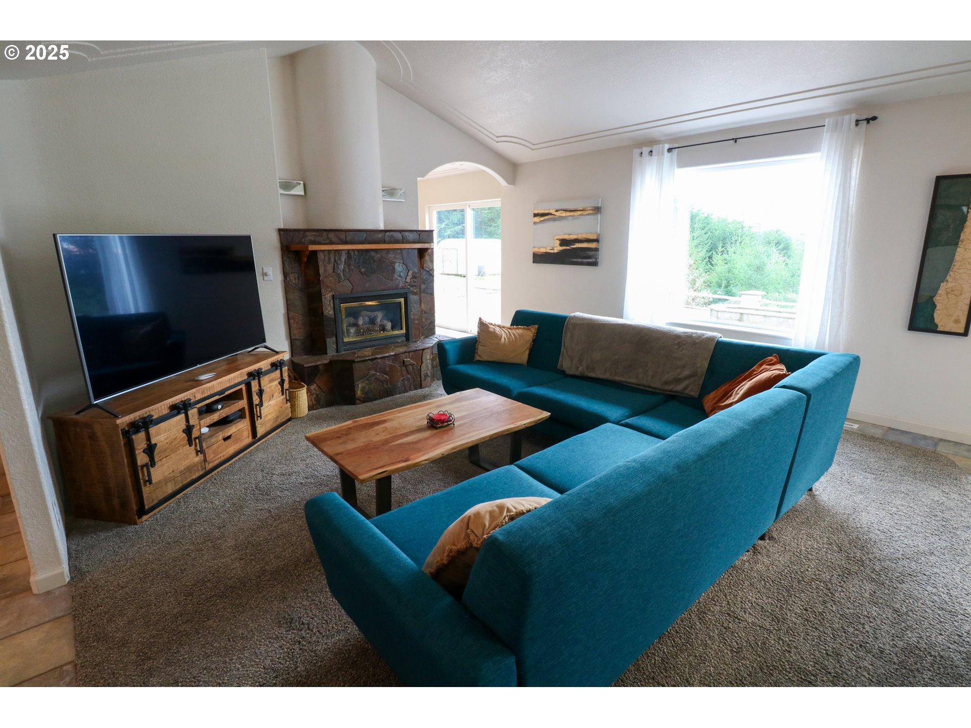 94088 Kirkendall Lane North Bend, OR 97459 - Photo 21 of 46 a living room with furniture a flat screen tv and a fireplace