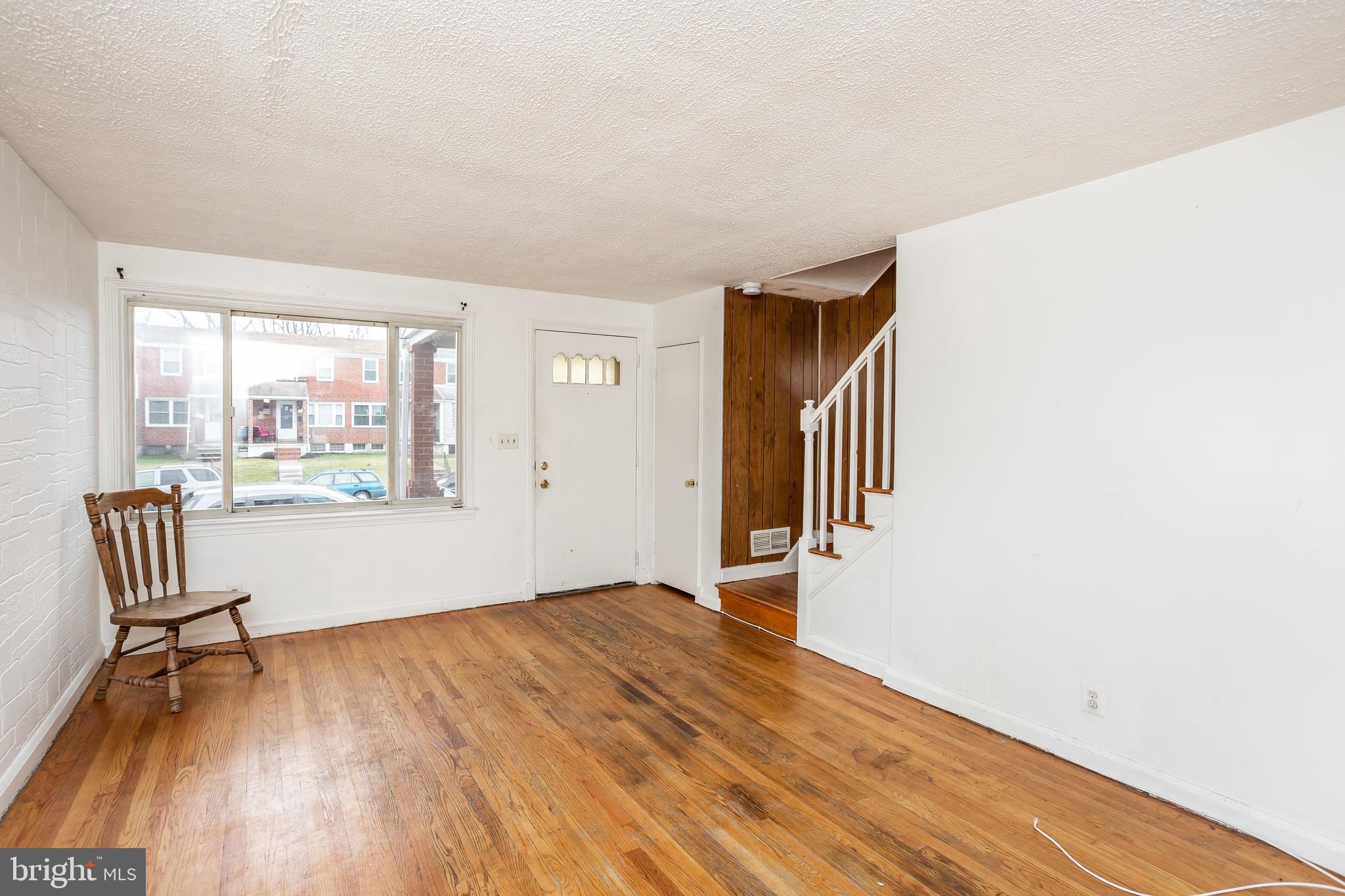 728 Aldworth Road Baltimore, MD 21222 - Photo 4 of 21 a view of an empty room with a window and wooden floor