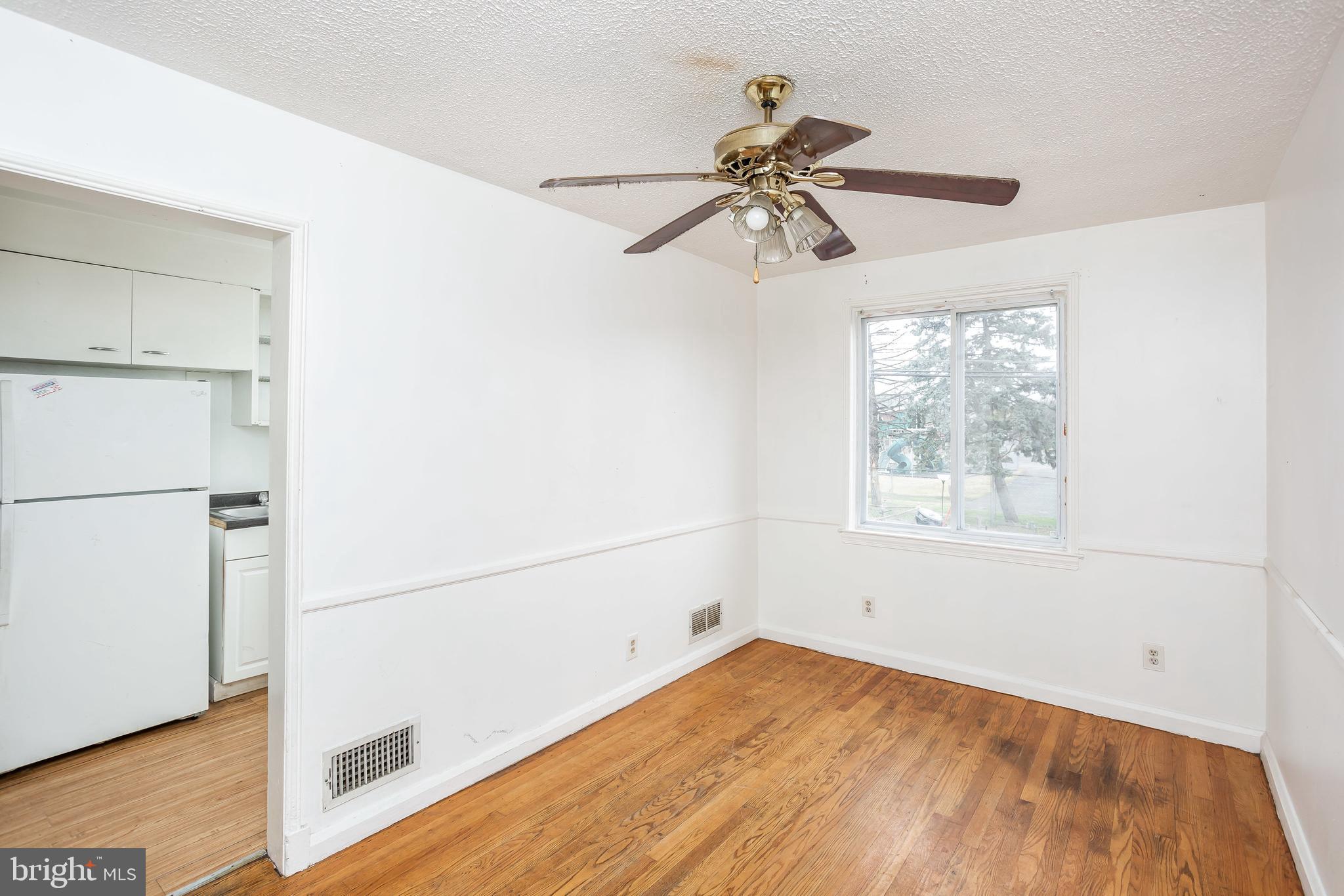 728 Aldworth Road Baltimore, MD 21222 - Photo 5 of 21 a view of an empty room with wooden floor and a window