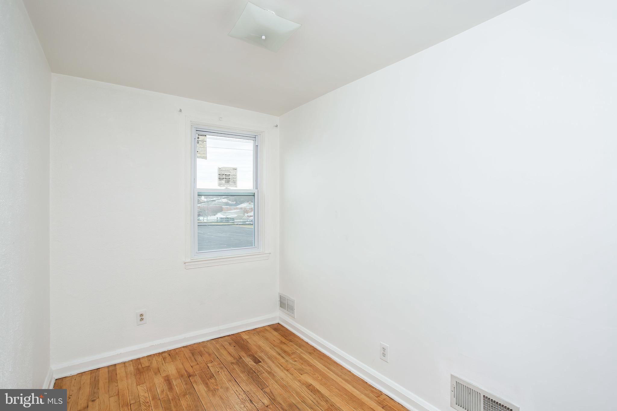 728 Aldworth Road Baltimore, MD 21222 - Photo 8 of 21 a view of a small space with wooden floor and a window